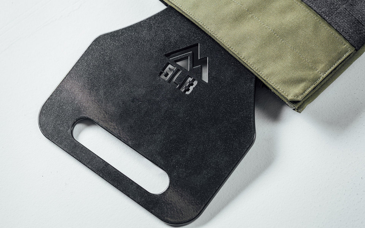 5lb Strata Weight Vest Plate going in to the Strata Weight Vest, durable steel construction, ergonomic rib contour, tapered edges, top/bottom handles, compatible with REP Strata™ vest for functional fitness and HIIT from Rep Fitness UK | Shop Premium Gym Equipment for Home & Commercial Use, Best Online Gym Equipment UK