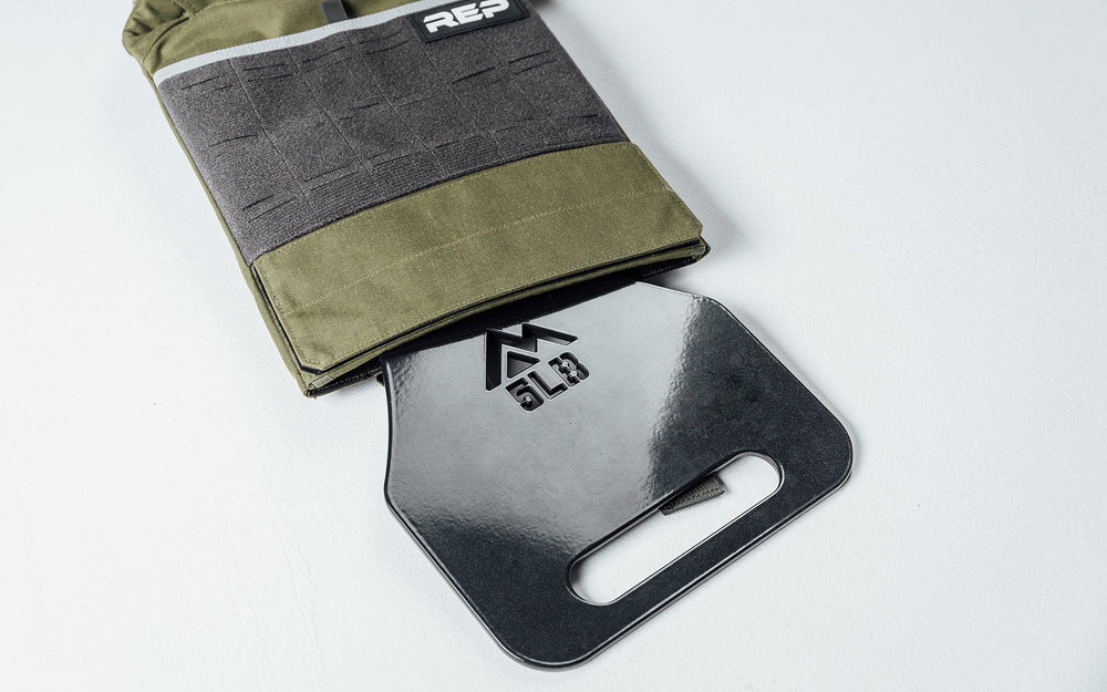 5lb Strata Weight Vest Plate going into the Strata Weight Vest at slight angle, durable steel construction, ergonomic rib contour, tapered edges, top/bottom handles, compatible with REP Strata™ vest for functional fitness and HIIT from Rep Fitness UK | Shop Premium Gym Equipment for Home & Commercial Use, Best Online Gym Equipment UK