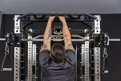 Athlete doing a narrow pull-up on the Crossmember Multi-Grip Pull-Up Bar on the front of a PR-5000 rack