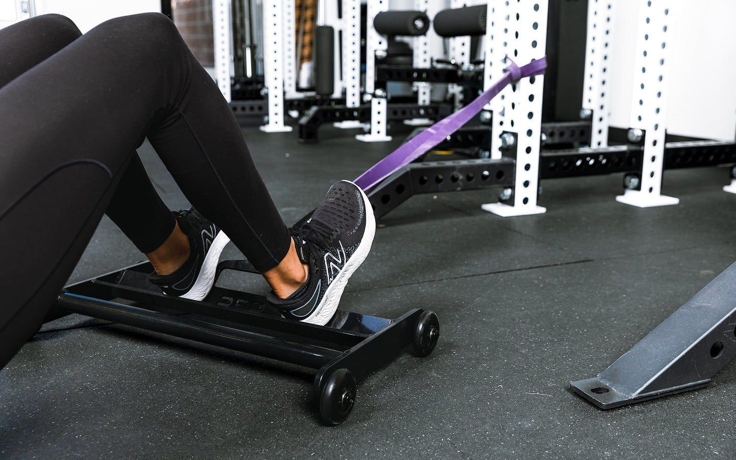 Athlete using glute ham roller with bands attached to a rack ideal for strengthening  posterior chain muscles lightweight and portable perfect for home gyms and commercial facilities from Rep Fitness UK | Shop Premium Gym Equipment for Home & Commercial Use Online | Best Online Gym 