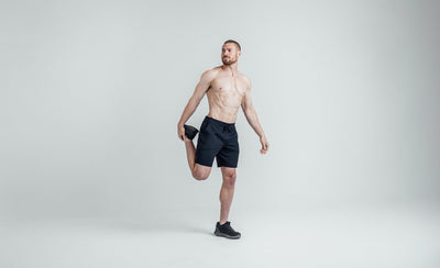 Athlete stretching in REP Men’s Apollo Shorts with a 9 inch inseam in Heather Navy/Cool Gray