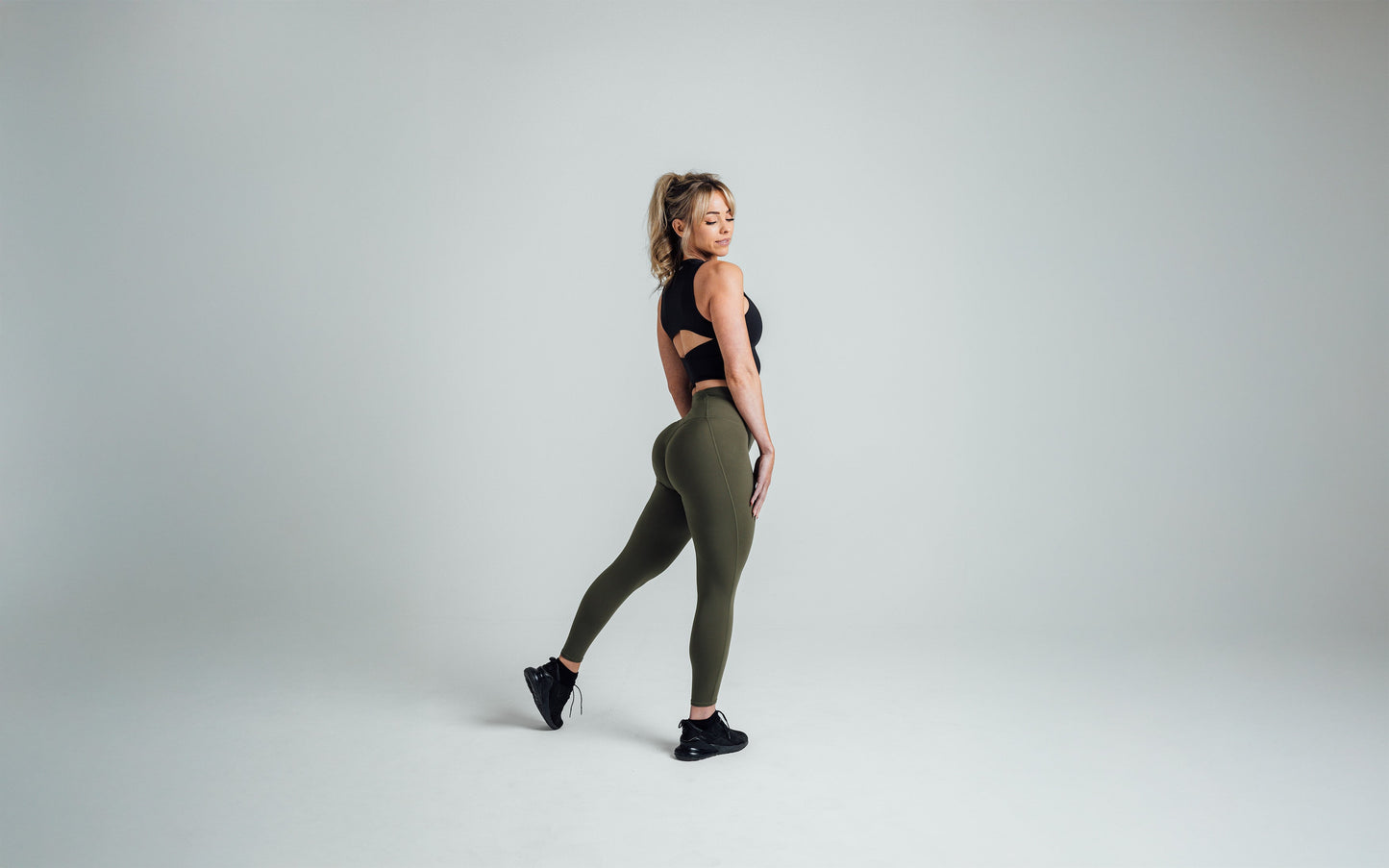 Side shot of an athlete striking a pose while wearing the REP Rhea Tank in Black