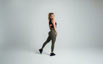 Side shot of an athlete striking a pose while wearing the REP Rhea Tank in Black