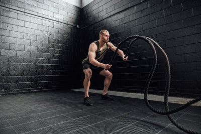 Athlete with battle ropes wearing Heather Olive Sigmatech Tank Top