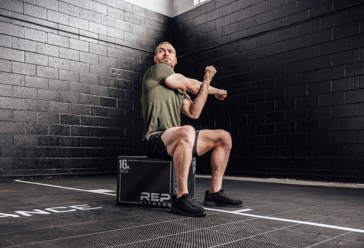 Athlete stretching in a Heather Olive Sigmatech Shirt