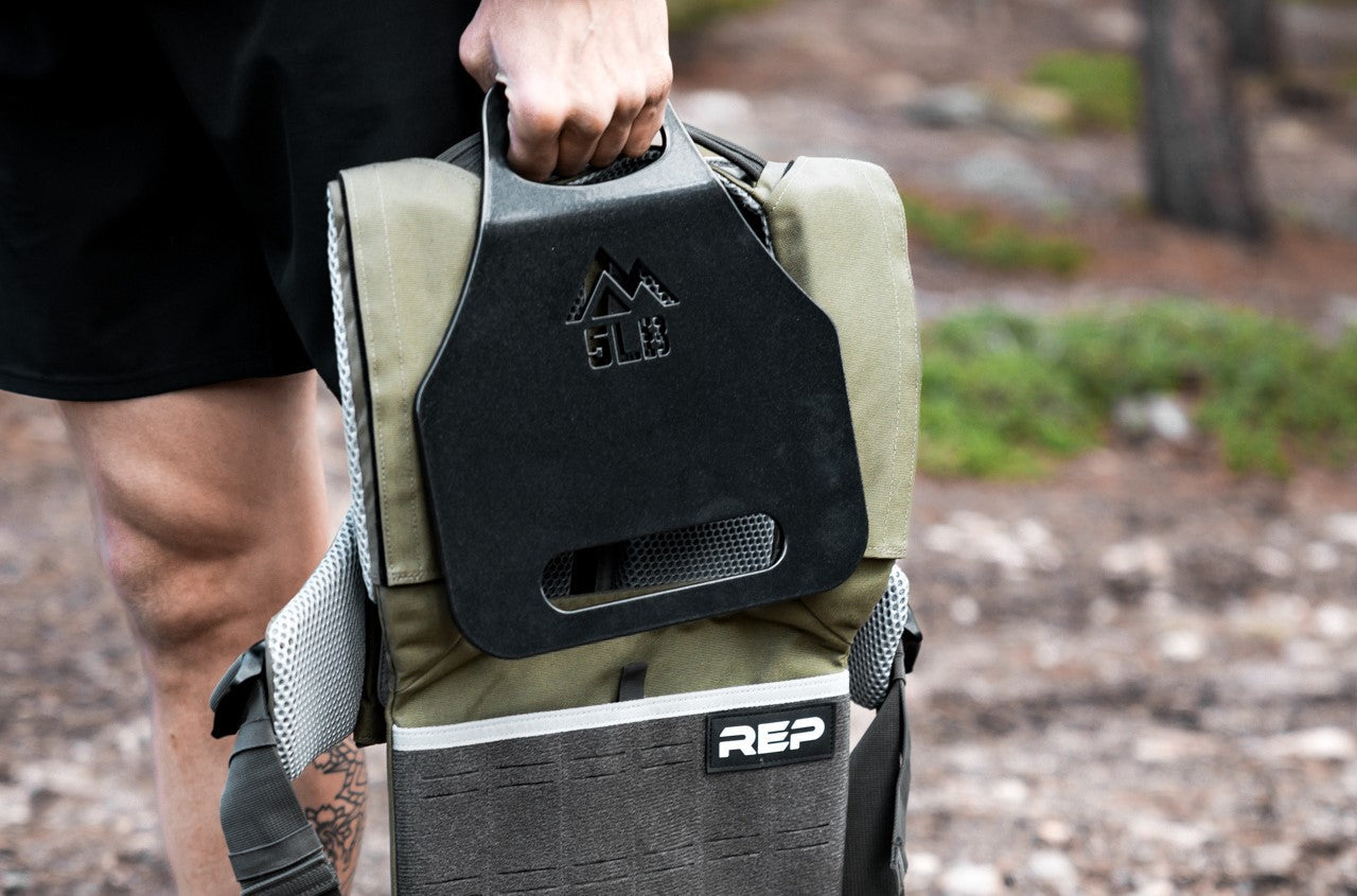 Athlete carrying the olive Strata Weight Vest and 5lb plate, REP Strata™ vest for functional fitness and HIIT from Rep Fitness UK | Shop Premium Gym Equipment for Home & Commercial Use, Best Online Gym Equipment UK