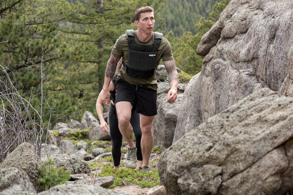 Athletes hiking with the Black Strata Weight Vest, adjustable fit, padded ergonomic design, durable 750D Cordura®, secure plate compartments, and versatile use for strength, HIIT, and functional fitness from Rep Fitness UK | Shop Premium Gym Equipment for Home & Commercial Use, Best Online Gym Equipment UK