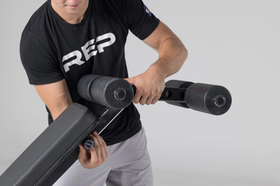 Side view of Leg Roller Attachment sliding into the end of AB-5000 adjustable bench, secured with knob for decline exercises from Rep Fitness UK | Shop Best Premium Gym Equipment for Home & Commercial Use Online