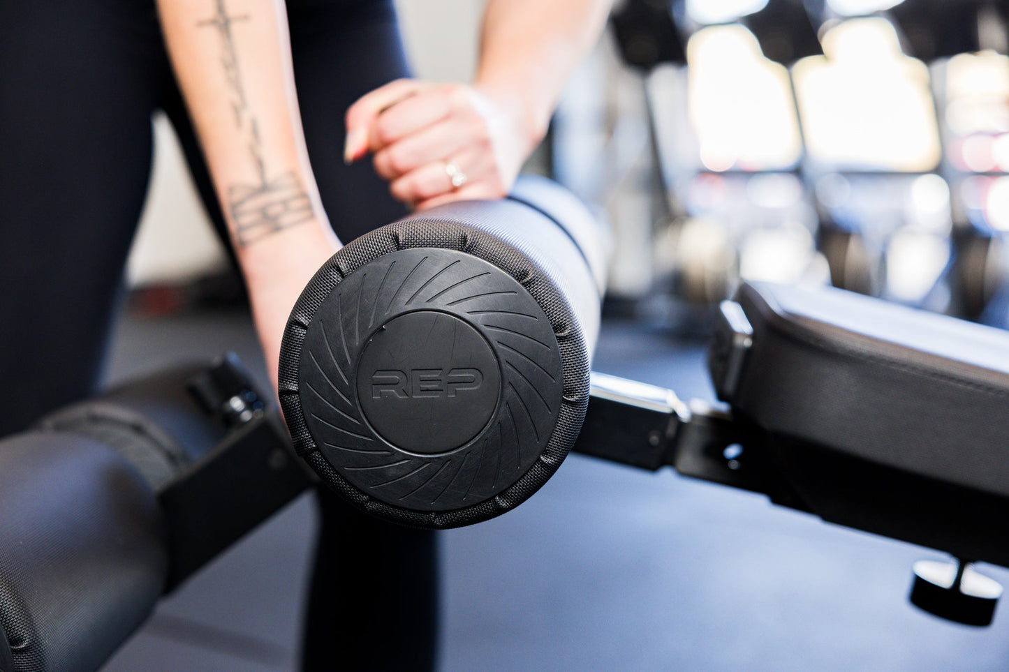 Close-up of an athlete installing the Adjustable Bench Leg Roller Attachment 2.0 from Rep Fitness UK | Shop Best Premium Gym Equipment for Home & Commercial Use Online