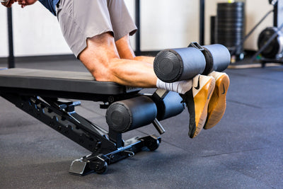 Athlete doing Nordic Hamstring curls with the Adjustable Bench Leg Roller Attachment 2.0 from Rep Fitness UK | Shop Best Premium Gym Equipment for Home & Commercial Use Online