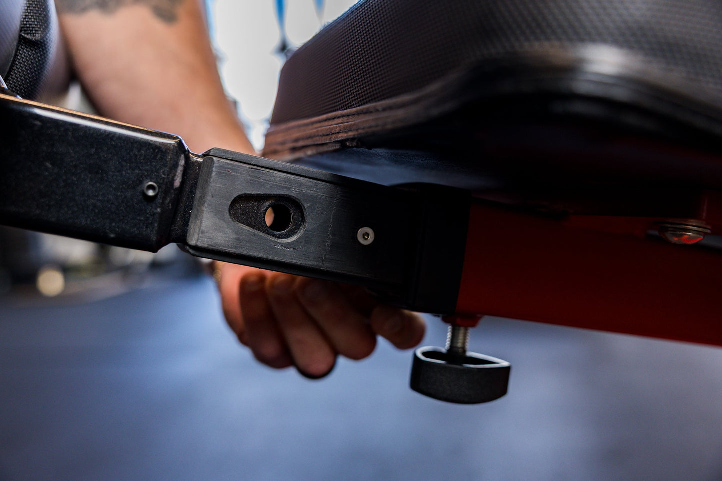 Close-up of an athlete installing the Adjustable Bench Leg Roller Attachment 2.0 into the bench's receiver from Rep Fitness UK | Shop Best Premium Gym Equipment for Home & Commercial Use Online