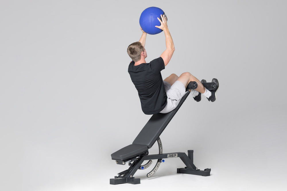 Man using adjustable bench leg roller attachment from Rep Fitness UK | Shop Best Premium Gym Equipment for Home & Commercial Use Online