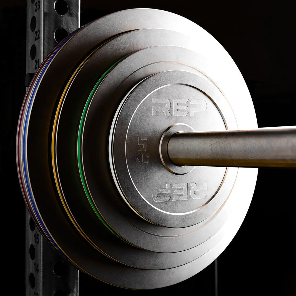 Calibrated Steel Plates in KG loaded onto a barbell on a PR-5000 rack from Rep Fitness UK | Shop Best Premium Gym Equipment for Home & Commercial Use Online