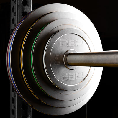Calibrated Steel Plates in KG loaded onto a barbell on a PR-5000 rack from Rep Fitness UK | Shop Best Premium Gym Equipment for Home & Commercial Use Online