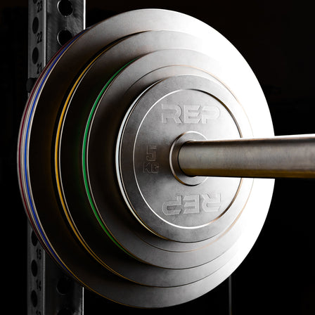 Calibrated Steel Plates in KG loaded onto a barbell on a PR-5000 rack from Rep Fitness UK | Shop Best Premium Gym Equipment for Home & Commercial Use Online