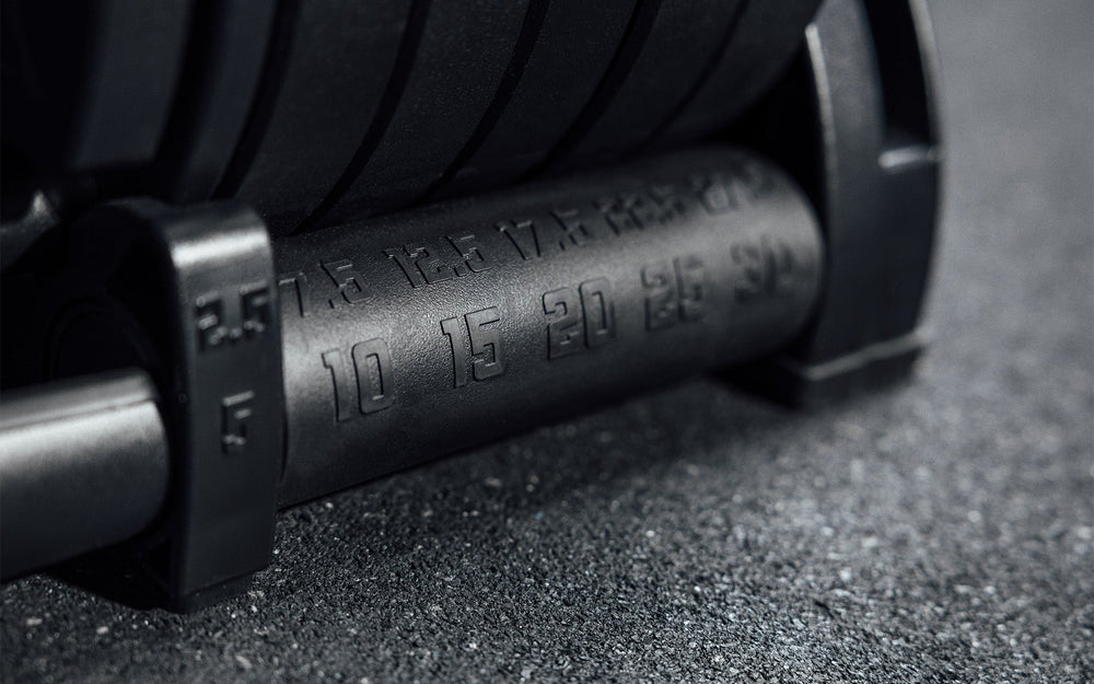 Close-up of metal detailing on Premium QuickDraw dumbbells with adjustable weight, fast switch adjustable  weight range technology and secure Lock-N-Load switches on a storage cart from Rep Fitness UK | Shop Premium Gym Equipment for Home & Commercial Use, Best Online Gym Equipment UK