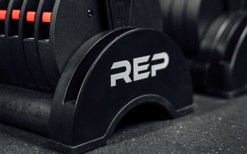 Close-up of side REP brand detailing on Premium QuickDraw dumbbells with adjustable weight, fast switch adjustable  weight range technology and secure Lock-N-Load switches on a storage cart from Rep Fitness UK | Shop Premium Gym Equipment for Home & Commercial Use, Best Online Gym Equipment UK