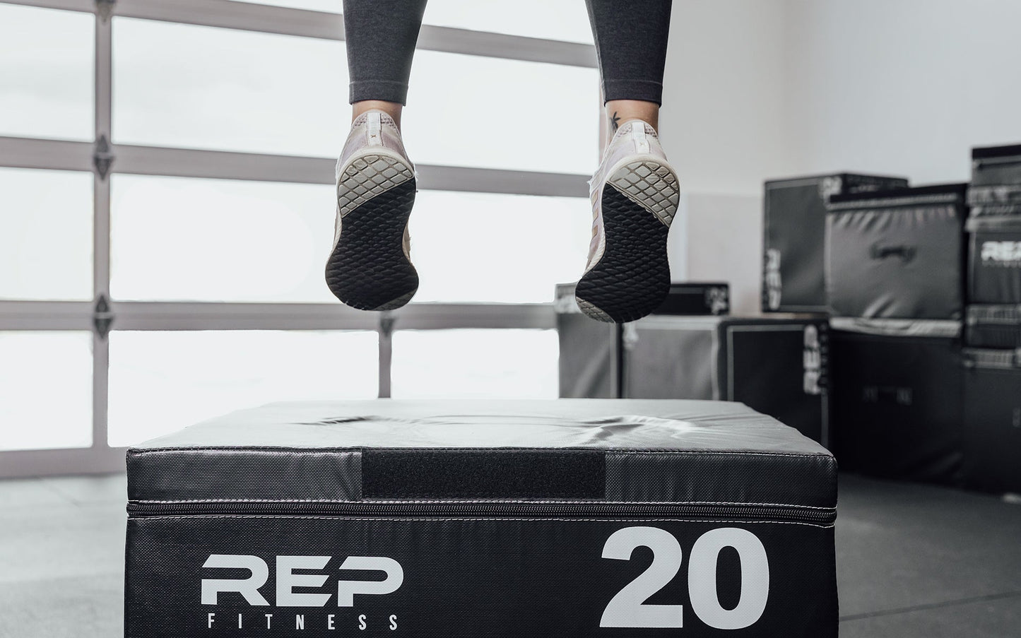 Female athlete performing box jumps on a 20" REP Stackable Soft Plyo Box from Rep Fitness UK | Shop Best Premium Gym Equipment for Home & Commercial Use Online