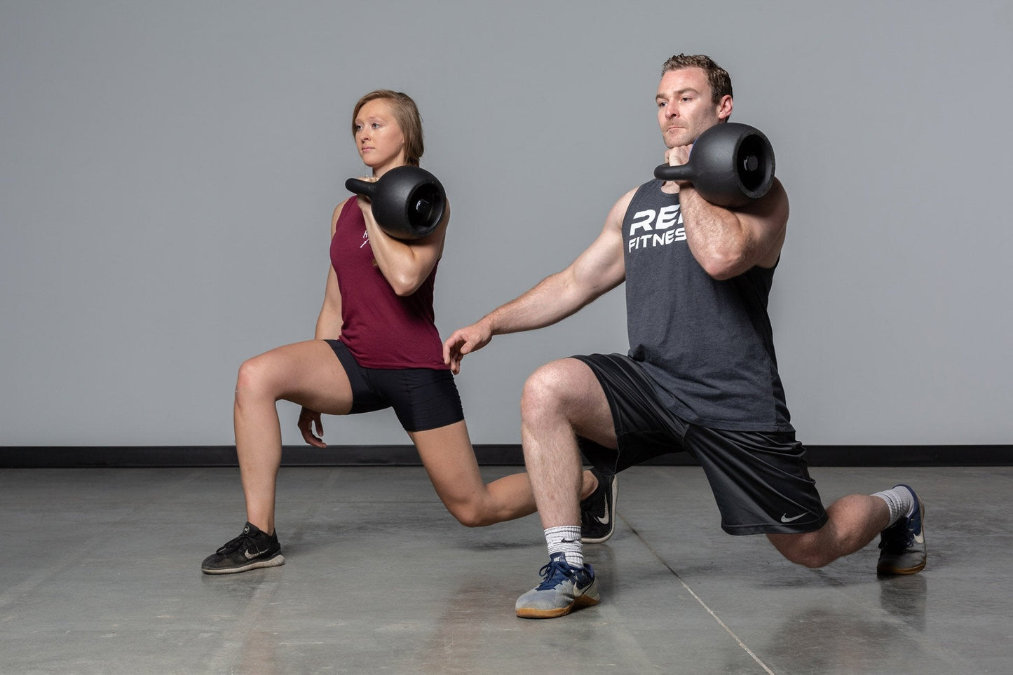 Couple squatting with adjustable kettlebells from Rep Fitness UK, quick weight adjustment, non-slip matte powder coat, rubber base, and versatile for home gyms| Shop Premium Gym Equipment for Home & Commercial Use, Best Online Gym Equipment UK