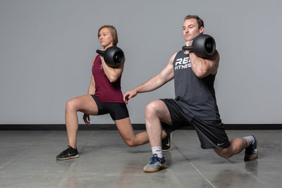 Couple squatting with adjustable kettlebells from Rep Fitness UK, quick weight adjustment, non-slip matte powder coat, rubber base, and versatile for home gyms| Shop Premium Gym Equipment for Home & Commercial Use, Best Online Gym Equipment UK