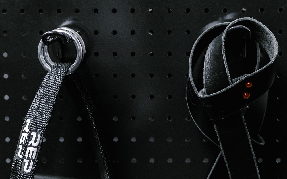 Close up of accessories hanging on pegboard storage hooks.