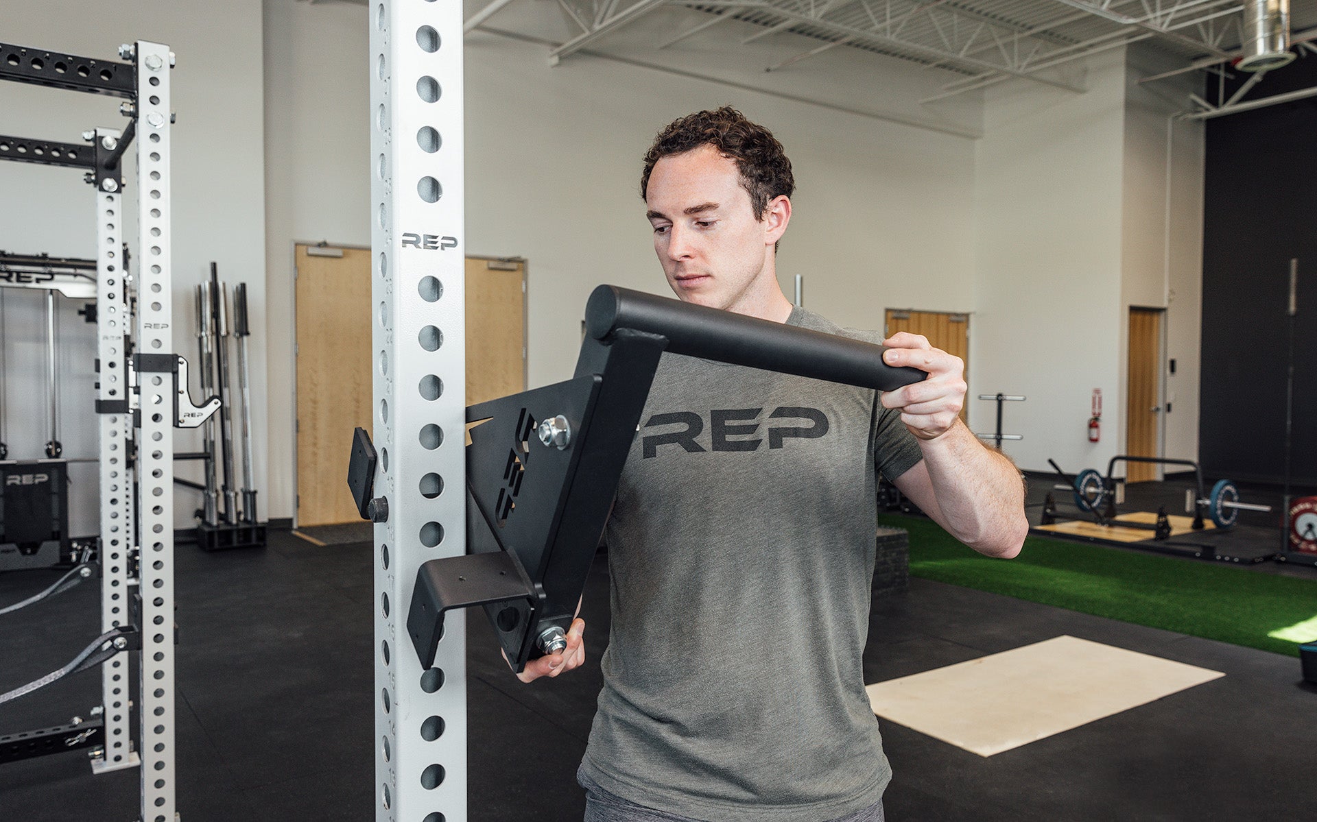 Drop-In Dip Attachment Being Installed on PR-5000 Power Rack, heavy-duty 11-gauge steel dip handles for power racks; 810 lb capacity, double C-cup mounting for stability, plastic-lined brackets to protect uprights, matte black powder coat textured grips, and laser-cut REP mountain design for premium aesthetic from Rep Fitness UK | Shop Premium Gym Equipment for Home & Commercial Use, Best Online Gym Equipment