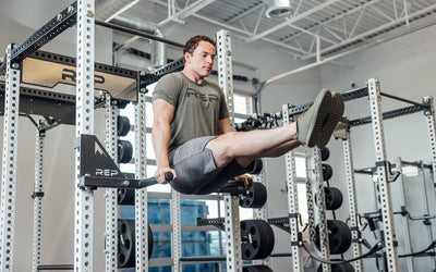 Drop-In Dip Attachment on PR-5000 Power Rack Being Use for L-Sit Hold, heavy-duty 11-gauge steel dip handles for power racks; 810 lb capacity, double C-cup mounting for stability, plastic-lined brackets to protect uprights, matte black powder coat textured grips, and laser-cut REP mountain design for premium aesthetic from Rep Fitness UK | Shop Premium Gym Equipment for Home & Commercial Use, Best Online Gym Equipment UK