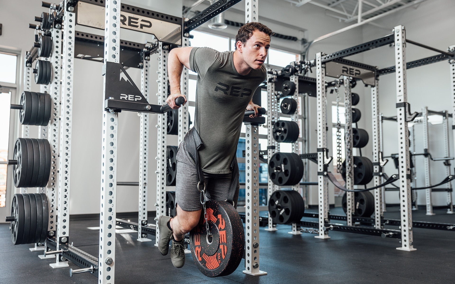 Drop-In Dip Attachment on PR-5000 Power Rack Being Used for Weighted Dips by man, heavy-duty 11-gauge steel dip handles for power racks; 810 lb capacity, double C-cup mounting for stability, plastic-lined brackets to protect uprights, matte black powder coat textured grips, and laser-cut REP mountain design for premium aesthetic from Rep Fitness UK | Shop Premium Gym Equipment for Home & Commercial Use, Best Online Gym Equipment