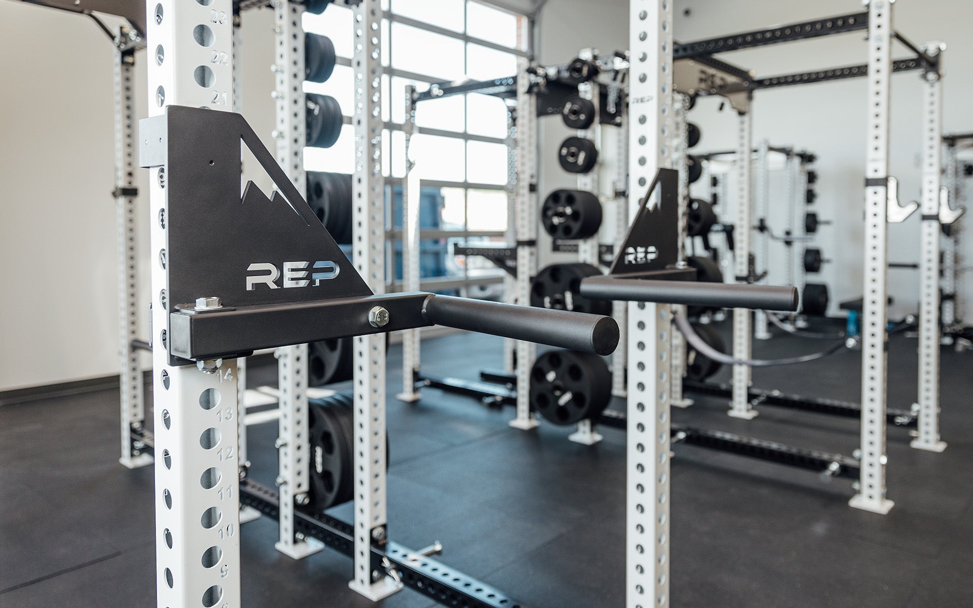 Drop-In Dip Attachment on PR-5000 Power Rack  Close Up, heavy-duty 11-gauge steel dip handles for power racks; 810 lb capacity, double C-cup mounting for stability, plastic-lined brackets to protect uprights, matte black powder coat textured grips, and laser-cut REP mountain design for premium aesthetic from Rep Fitness UK | Shop Premium Gym Equipment for Home & Commercial Use, Best Online Gym Equipment UK