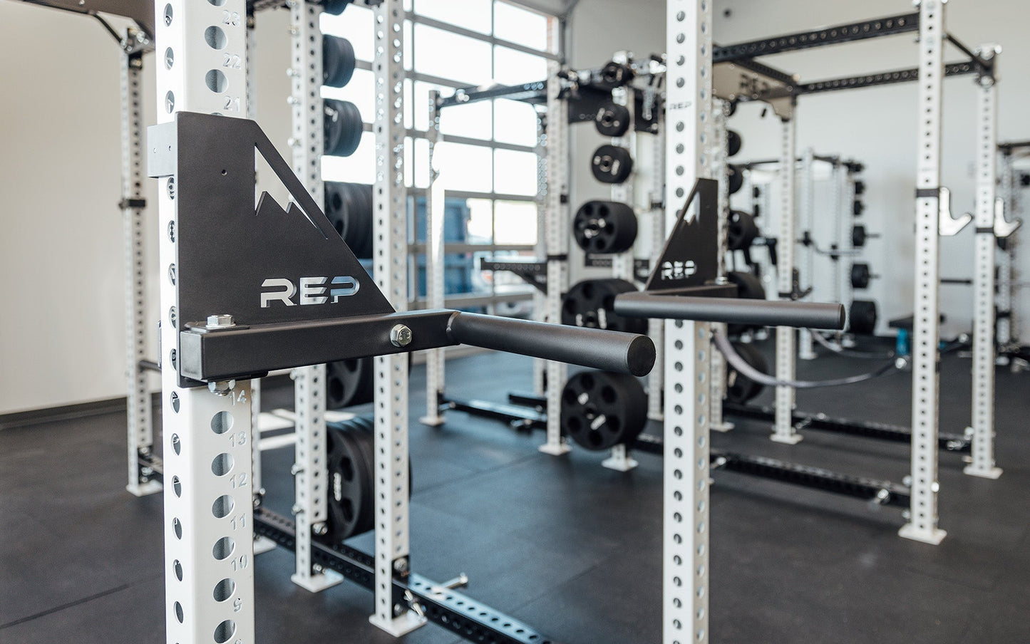Drop-In Dip Attachment on PR-5000 Power Rack  Close Up, heavy-duty 11-gauge steel dip handles for power racks; 810 lb capacity, double C-cup mounting for stability, plastic-lined brackets to protect uprights, matte black powder coat textured grips, and laser-cut REP mountain design for premium aesthetic from Rep Fitness UK | Shop Premium Gym Equipment for Home & Commercial Use, Best Online Gym Equipment UK