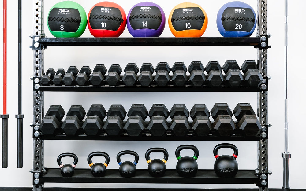 Dumbbells and kettlebells on Dumbbell and Kettlebell Storage Shelves – heavy-duty 11-gauge reversible gym storage shelf for dumbbells, kettlebells, balls, and accessories; 72” metallic black powder-coated rack with laser-cut REP logo, secure lips, and bolt-on design compatible with 4000 and 5000 Series power racks for organized home or commercial gym storage from Rep Fitness UK | Shop Premium Gym Equipment for Home & Commercial Use, Best Online Gym Equipment UK