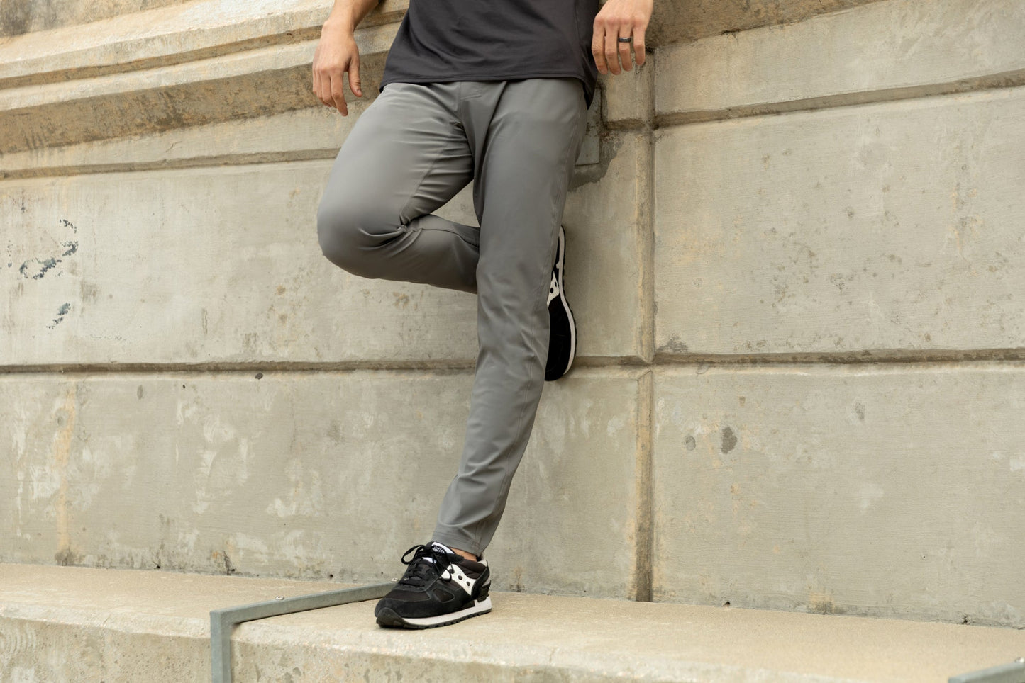 Men's Pants & Joggers - Athlete in grey Men's Felix Pants 2.0 leaning on a ledge