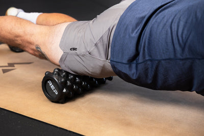 Person using High Density Foam Roller to roll out quads on cork yoga mat from Rep Fitness UK | Shop Best Premium Gym Equipment for Home & Commercial Use Online