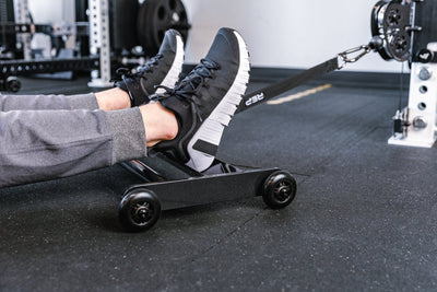 Feet resting on the foot tray of the Glute Ham Roller with the strap attached to a functional trainer ideal for strengthening posterior chain muscles lightweight and portable perfect for home gyms and commercial facilities from Rep Fitness UK | Shop Premium Gym Equipment for Home & Commercial Use Online | Best Online Gym 