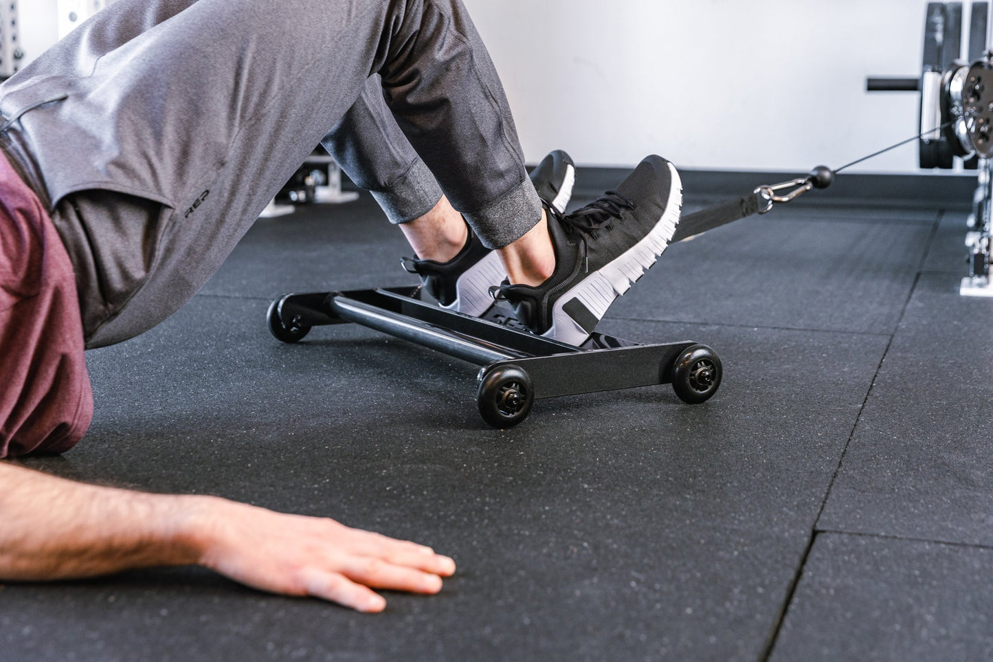 Athlete using Glute Ham Roller with strap attached to a functional trainer ideal for strengthening posterior chain muscles lightweight and portable perfect for home gyms and commercial facilities from Rep Fitness UK | Shop Premium Gym Equipment for Home & Commercial Use Online | Best Online Gym 