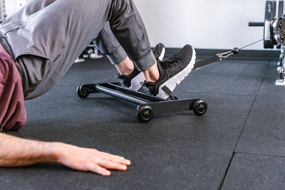 Athlete using Glute Ham Roller with strap attached to a functional trainer ideal for strengthening posterior chain muscles lightweight and portable perfect for home gyms and commercial facilities from Rep Fitness UK | Shop Premium Gym Equipment for Home & Commercial Use Online | Best Online Gym 