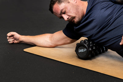 Man using High Density Foam Roller to roll out lats on a cork yoga mat from Rep Fitness UK | Shop Best Premium Gym Equipment for Home & Commercial Use Online