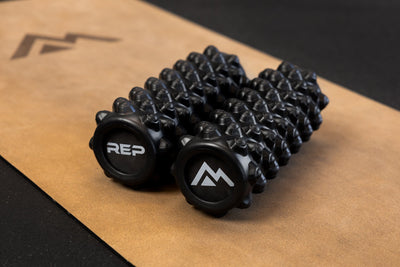 Black "peak" textured High Density Foam Roller with 'REP' and Mountain logos on a cork yoga mat from Rep Fitness UK | Shop Best Premium Gym Equipment for Home & Commercial Use Online