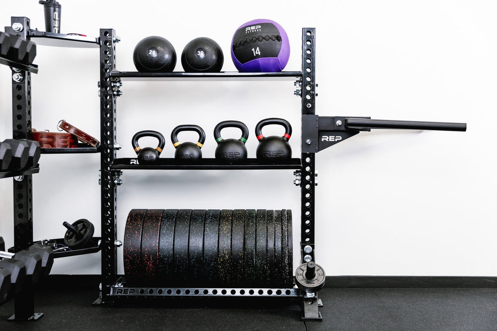 Kettlebells, medicine ball and weights on Medicine balls on Ball & Plate Storage Shelf – heavy-duty 11-gauge steel gym storage shelf for bumper plates, medicine balls, and slam balls, 600lb capacity, 41” wide with laser-cut REP logo, metallic black powder-coat finish, compatible with PR-5000 power rack for organized, space-saving gym setup from Rep Fitness UK | Shop Premium Gym Equipment for Home & Commercial Use, Best Online Gym Equipment UK