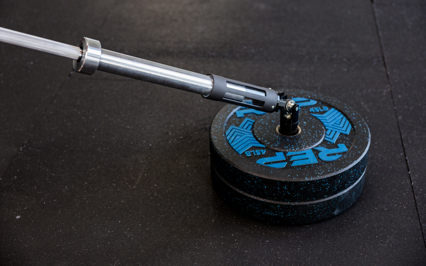 A barbell being slid into the polycarbonate sleeve of the Free Standing REP® x Kleva Built® Adroit Landmine from Rep Fitness UK | Shop Premium Gym Equipment for Home & Commercial Use Online | Best Online Gym Equipment UK