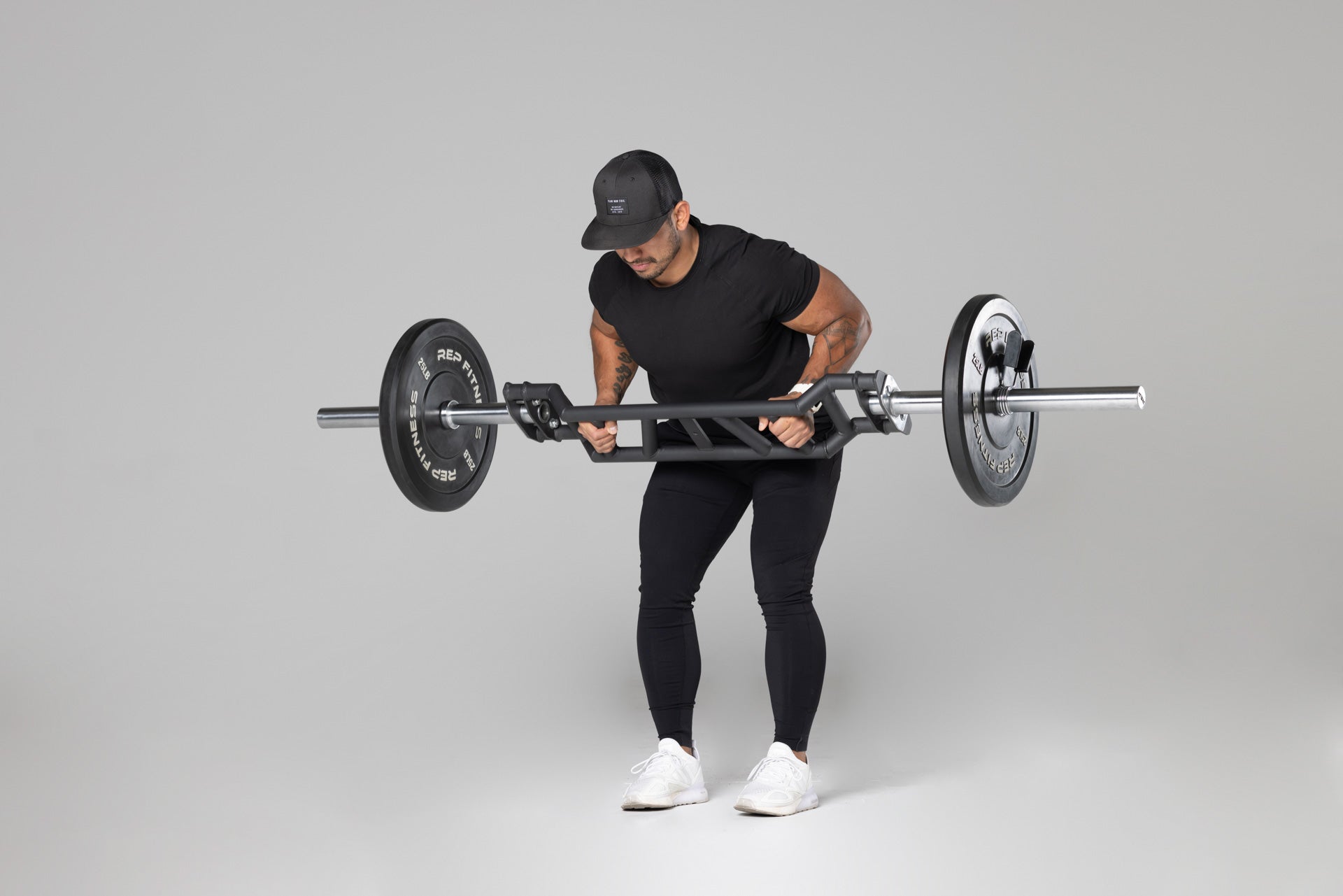 Lifter using loaded Cambered Swiss Bar for bent over rows, premium chrome sleeve with REP logo, versatile multi-grip barbell with cambered design for greater range of motion and muscle engagement; features moderate knurling, round tubing for comfort, removable eyebolt for cable attachments, standard collar compatibility, and premium construction for advanced strength training from Rep Fitness UK | Shop Premium Gym Equipment for Home & Commercia | Best online gym shop UK