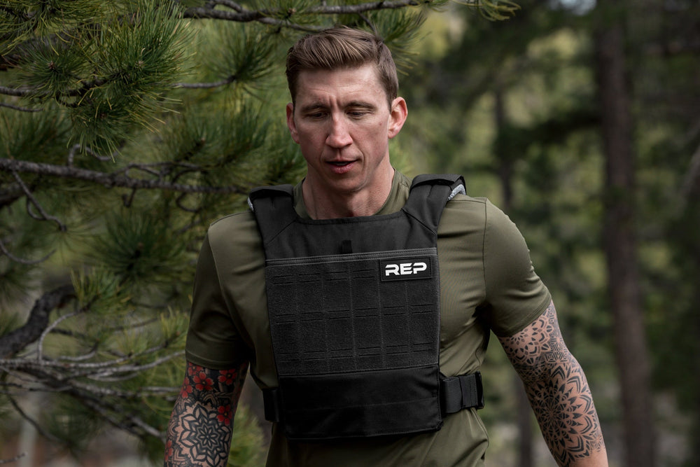 Male Athlete exercising in the woods with the Black Strata Weight Vest, adjustable fit, padded ergonomic design, durable 750D Cordura®, secure plate compartments, and versatile use for strength, HIIT, and functional fitness from Rep Fitness UK | Shop Premium Gym Equipment for Home & Commercial Use, Best Online Gym Equipment UK