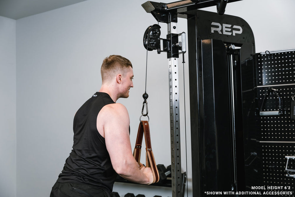 Man doing set of arm strength exercises using pulley on Arcadia™ max stand-alone functional trainer, premium full-sized cable machine with grips hanging on the back board from Rep Fitness UK | Shop Premium Gym Equipment for Home & Commercial Use Online.