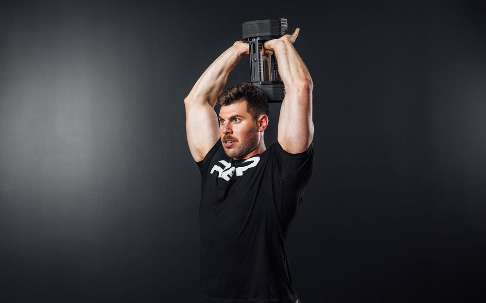 Man lifting Pepin dumbbell behind back for upper arm workout from Rep Fitness UK | Shop Premium Gym Equipment for Home & Commercial Use Online | Best only gym equipment UK