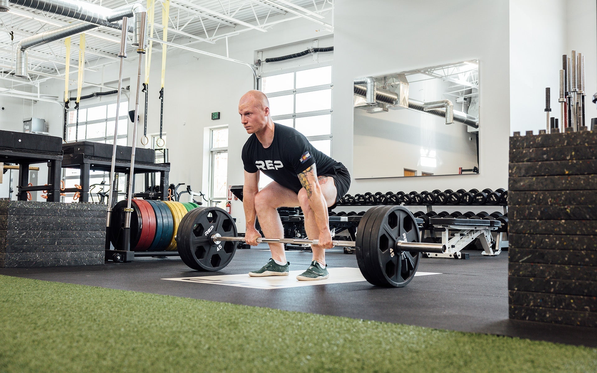 Man lifting with REP Fully Stainless Steel Double Black Diamond Power Bar, elite 20kg powerlifting barbell with ultra-aggressive mountain knurling, 29mm stiff shaft, bronze bushings, and IPF-standard specs, built for maximum grip and durability; available in stainless steel or Cerakote finishes for premium performance and corrosion resistance from Rep Fitness UK | Shop Premium Gym Equipment for Home & Commercial Use, Best UK Gym Equipment Online