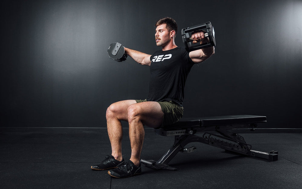 Man sitting on bench lifting Pepin dumbbells on exercise bench from Rep Fitness UK | Shop Premium Gym Equipment for Home & Commercial Use Online | Best only gym equipment UK
