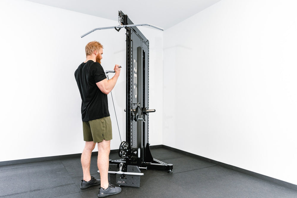 Man standing using Adonis™ Cable Tower plate loaded, Selectorized no Pegasus with base support, premium space-saving cable machine for home or commercial gyms, 1:1 and 2:1 pulley ratios, 34 cable positions, and compatibility with REP’s 5000 Series racks, Pegasus™ attachment, and Modular Storage System for unmatched versatility and performance from Rep Fitness UK | Shop Premium Gym Equipment for Home & Commercial Use, Best Online Gym Equipment