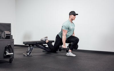 Nighthawk matte black bench man exercising legs holding Pepin dumbbells for reps from Rep Fitness UK | Shop Premium Gym Equipment for Home & Commercial Use Online