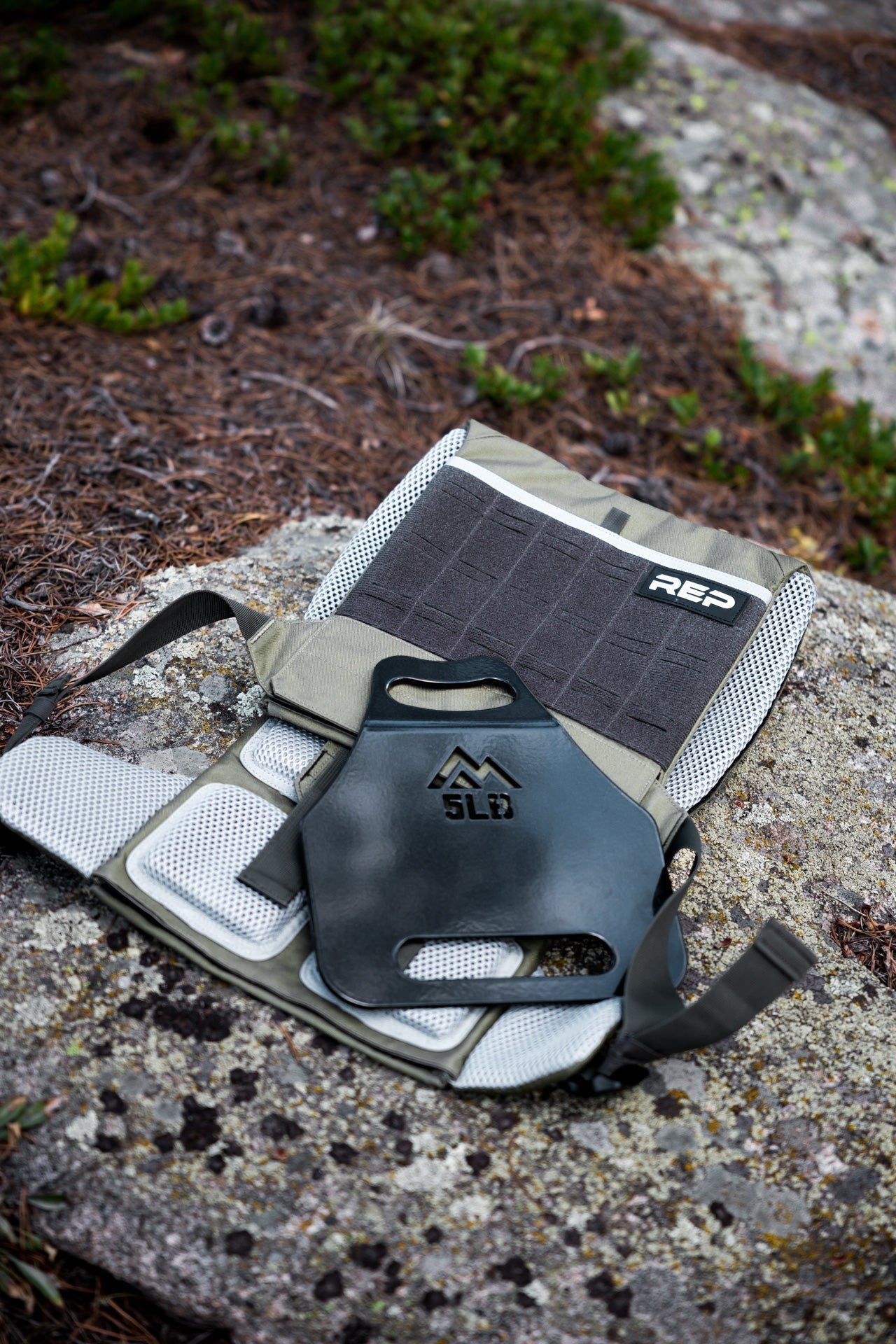 Olive Strata Weight Vest and 5lb plate laid out on forest floor, REP Strata™ vest for functional fitness and HIIT from Rep Fitness UK | Shop Premium Gym Equipment for Home & Commercial Use, Best Online Gym Equipment UK