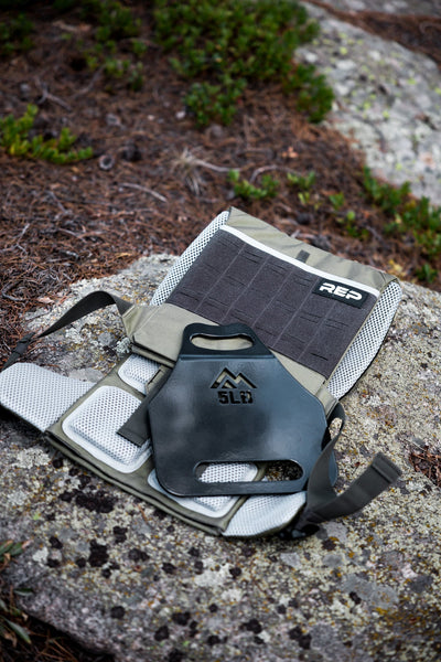 Olive Strata Weight Vest and 5lb plate on forest ground, Olive Strata Weight Vest with weight vest plate, adjustable fit, padded ergonomic design, durable 750D Cordura®, secure plate compartments, and versatile use for strength, HIIT, and functional fitness from Rep Fitness UK | Shop Premium Gym Equipment for Home & Commercial Use, Best Online Gym Equipment UK